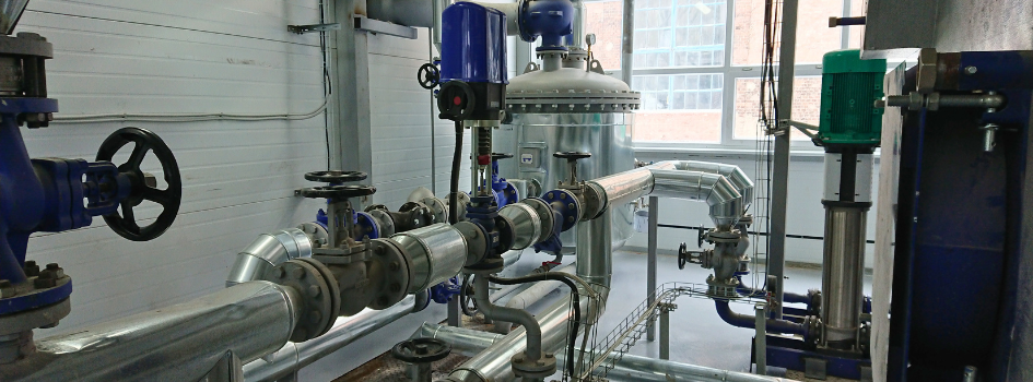 Industrial stainless steel piping, valves, and process equipment used in a fluid handling system where material compatibility is important.